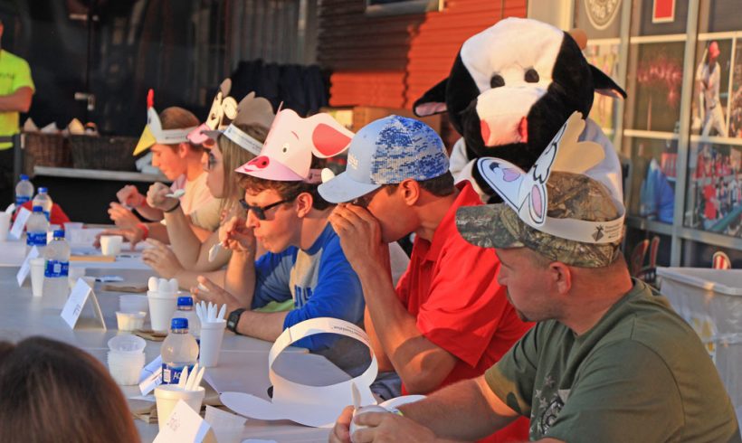 Cow mascot cheers on contestants during the ice cream eating contest.